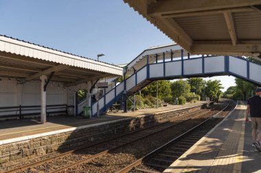 St Erth, Cornwall, İngiltere, İngiltere. 2022 yılı. St Erth İstasyonu platformları ve yaya köprüsü. Popüler kıyı şeridi hattı için kanalı değiştir. Batı Cornwall 'da bir tatil köyü..