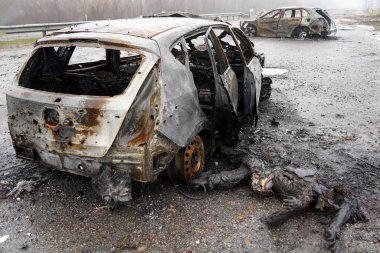 Burnt car during the war in Ukraine. Destroyed buildings, roads. Technique of civilian Ukraine