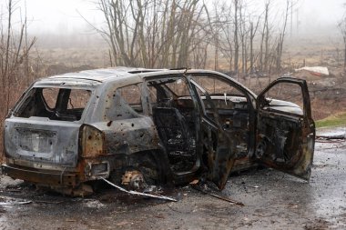 Burnt car during the war in Ukraine. Destroyed buildings, roads. Technique of civilian Ukraine
