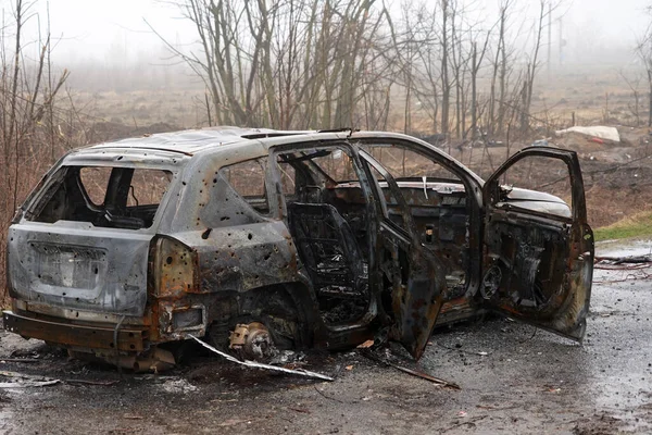 Ukrayna 'daki savaş sırasında yanmış bir araba. Yıkılmış binalar, yollar. Sivil Ukrayna Tekniği