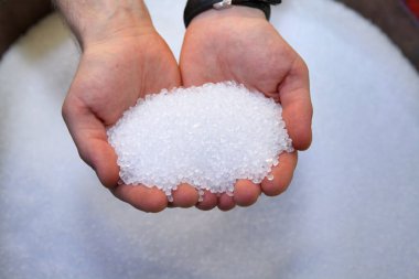Plastik granüller insanların elinde. Kalite denetimi
