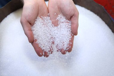 Plastik granüller insanların elinde. Kalite denetimi
