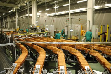 Üretim hattında bir sürü kurabiye var. Paketlemeden önce tatlı akışı. Makinede kraker paketliyorum. Yenilikçi üretim
