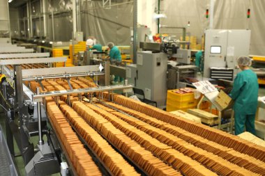 Üretim hattında bir sürü kurabiye var. Paketlemeden önce tatlı akışı. Makinede kraker paketliyorum. Yenilikçi üretim