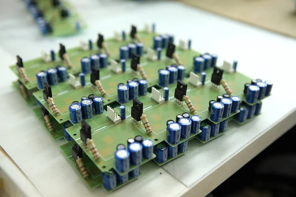 A man collects a printed circuit board. The worker solders the radio components and assembles the finished device. Manual assembly and control