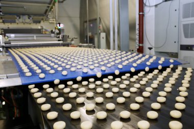 Close up of automated biscuit cookies shape forming machine. Selective focus. machine for making cookies in the factory. Conveyor belt with Cookie dough