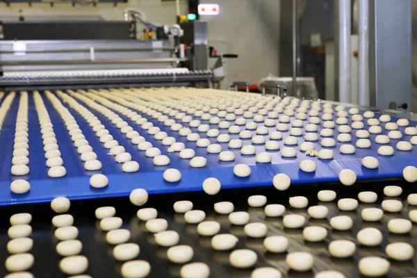 Close up of automated biscuit cookies shape forming machine. Selective focus. machine for making cookies in the factory. Conveyor belt with Cookie dough