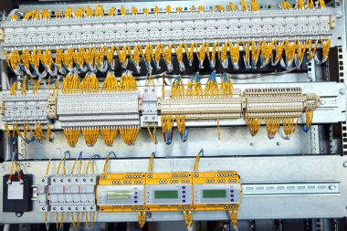Elektrik mühendisi, elektrik kabinesi kontrolündeki voltaj ve elektrik akımını ölçen bir testçi ve röle koruma sistemindeki kabloları kontrol ediyor. Körfez kontrol birimi. Orta gerilim şalteri..