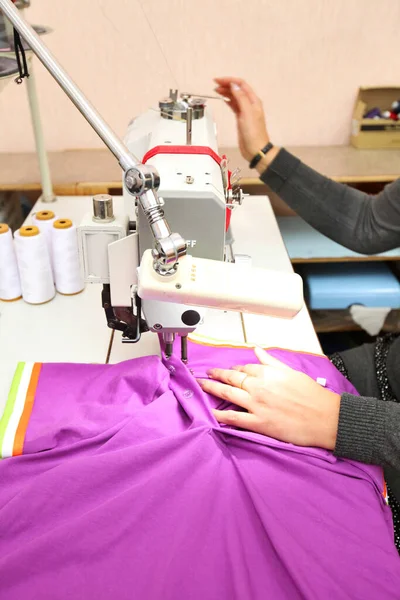 Shop for tailoring. A woman creates clothes on a sewing machine. Fashion industry for people. Stylish fashionista woman creating new cloth design collection. Tailor and sewing. People lifestyle and occupation concept.