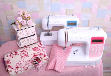 Composition from a sewing machine. Mannequin, flowers on a retro table and threads. Sewing supplies and composition with a sewing machine in the interior. With the letter M. The composition is unique for the fashion.