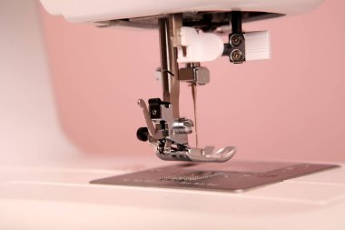 Composition from a sewing machine. Mannequin, flowers on a retro table and threads. Sewing supplies and composition with a sewing machine in the interior. With the letter M. The composition is unique for the fashion.