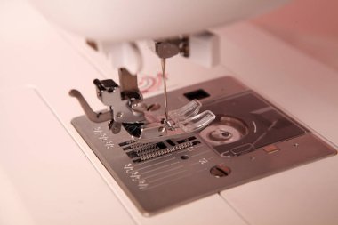 Composition from a sewing machine. Mannequin, flowers on a retro table and threads. Sewing supplies and composition with a sewing machine in the interior. With the letter M. The composition is unique for the fashion.