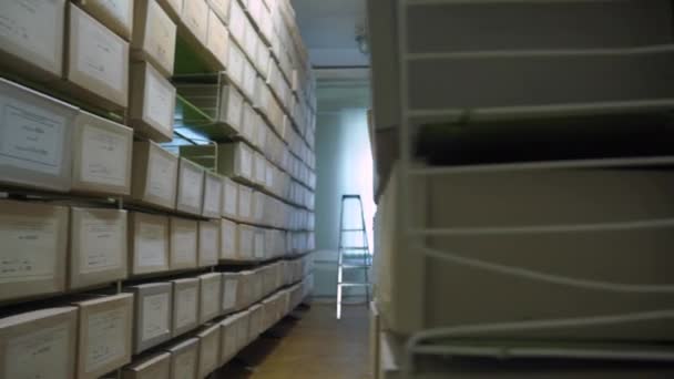 Rows of metal racks with archive boxes lying on shelves — Stock Video