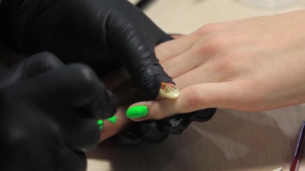 Маникюртист наносит красочный лак на ногти клиентов — стоковое видео
