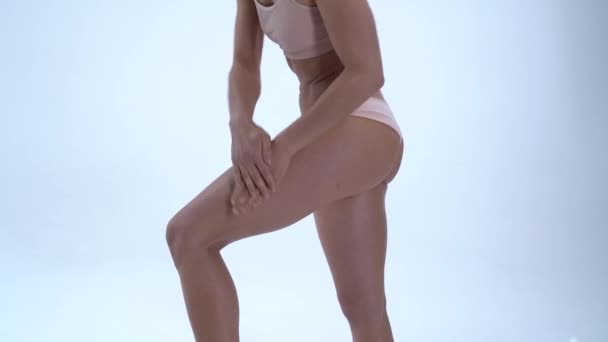 Model uses hands applying body oil on leg for advertising — Stock Video