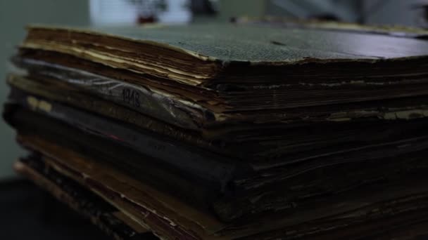 Стопка древних книг с желтыми страницами и потрепанными обложками — стоковое видео
