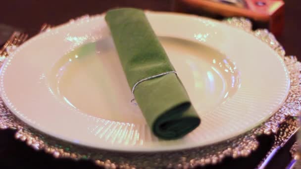 Șervețel verde pliat se află pe farfurie pe masă în restaurant — Videoclip de stoc