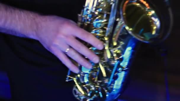 Hand of young man playing professionally saxophone in bar — Stock Video