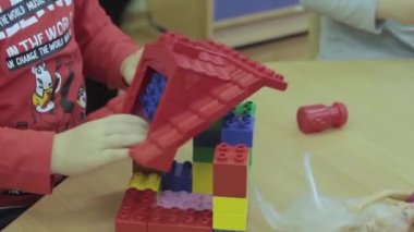 Küçük çocuk plastik inşaatçıyla oynuyor.