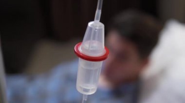 Hastane yatağında serum takılı serum damlası.