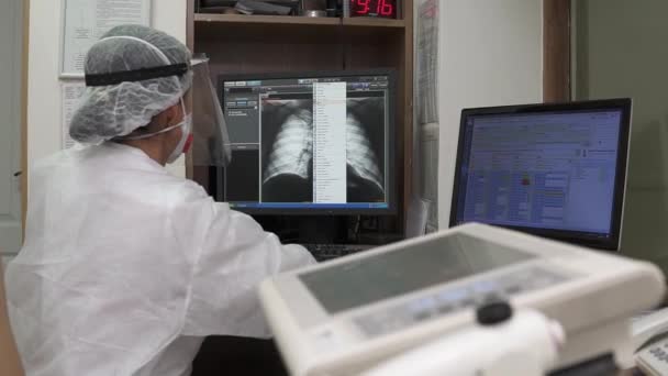 Doutor olha para raio-X de tórax na tela do computador no escritório — Vídeo de Stock