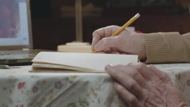 Male hands write notes with pencil in notepad on table — Stock Video