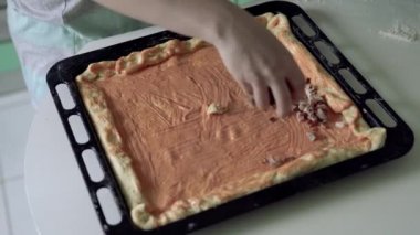 Kadın fırça tepsisinde pizza için fırçayla sos sürüyor.