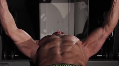 Genç sporcu halteri göğsüne kaldırıyor.