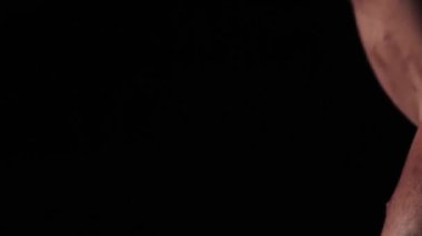 Sporcu vücudu ve kasları sallar. Yakın plan.