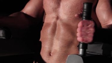 Sporcu adam simülatörde makineyi sallıyor.