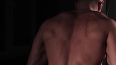 Erkek sporcu omuzlarını sallar ve koşu bandına geri döner.