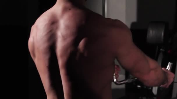 Young Man Handsome Guy Shakes His Back Muscles Simulator Close — Stock Video