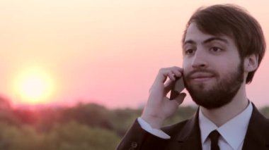 Sokakta telefonla konuşan genç bir adam. Şafakta anlaşma.