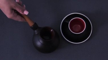 Kil tenceresi sıcak sobada kahve demler. Kahve yüzeye dökülür.