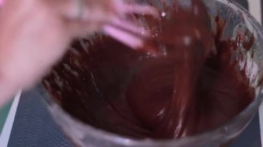 Kadın pasta için çikolata hamuru yoğuruyor.