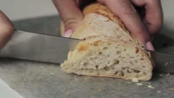 在厨房桌上用一把大刀切三明治面包 — 图库视频影像