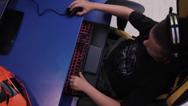 Pojke Headset Spelar Spel Datorn Sitter Vid Skrivbordet Nära Orange — Stockvideo