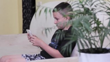 Adam tablete bakar ve oyun oynarken ellerini ekranda hareket ettirir.