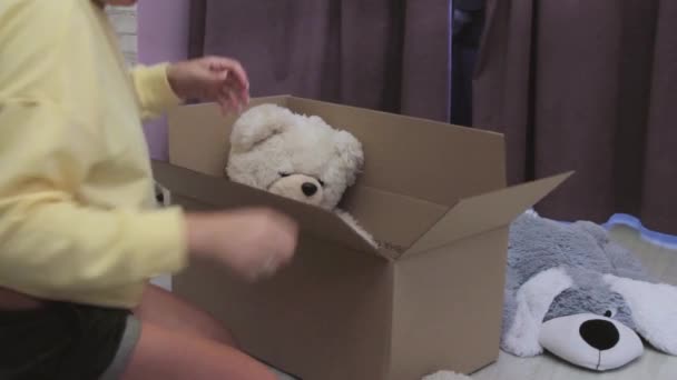 Jong Meisje Het Inpakken Van Een Doos Met Kinderen Zacht — Stockvideo