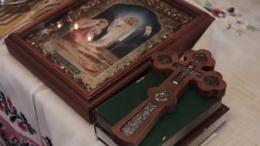 Sacred cross made of wood lies on the bible next to the icon. Ukraine, Kyiv - septembr 2022