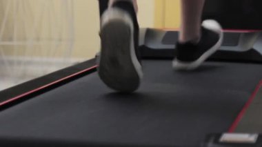 Özel bir evin spor salonundaki koşu bandına yakın çekimler yapılıyor.