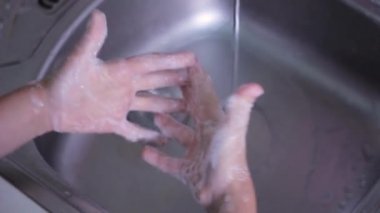 Mutfakta sabunla ellerini yıkıyorsun.