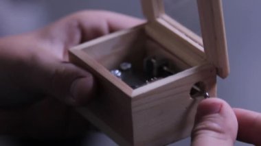 Erkek elleri ahşaptan yapılmış retro müzik kutusunu çalıyor. Kutunun yan görünümü