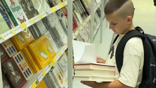 Young Guy Schoolboy Chooses Books Supermarket Bookstore Shelf Ukraine Kyiv — ストック動画