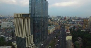 Cars drive along the road highway in a large stream in the city. Aerial view from a quadcopter. Urban landscape with high-rise buildings