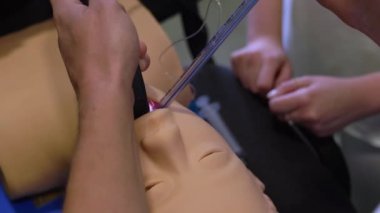 Erkek doktor, laringoskop kullanarak bir manikinin gırtlağına tüp yerleştiriyor. Klinikte solunum entübasyonu öğretiyorum.