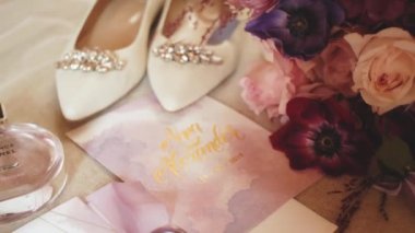 Close-up wedding accessories of the bride slow motion, wedding bouquet, brides shoes, wedding rings. Morning of the bride. Wedding accessories. 