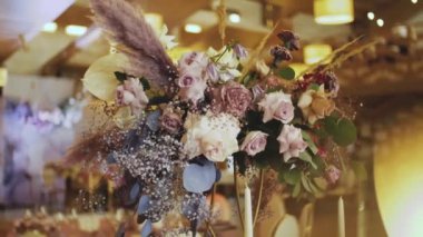 Bir buket çiçekle süslenmiş servis masaları. Düğün dekoru, çiçekler..