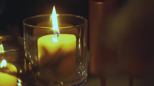 Hermoso jarrón de cristal con velas encendidas en cámara lenta — Vídeos de Stock
