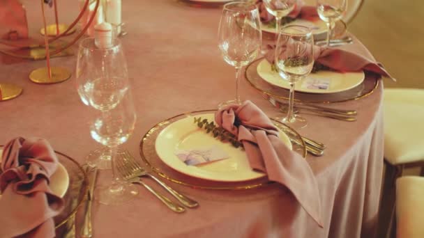 Schöne Hochzeitsdekoration, die alle in einer rosafarbenen Zeitlupe gehalten sind. Schöne Teller auf dem Tisch. — Stockvideo